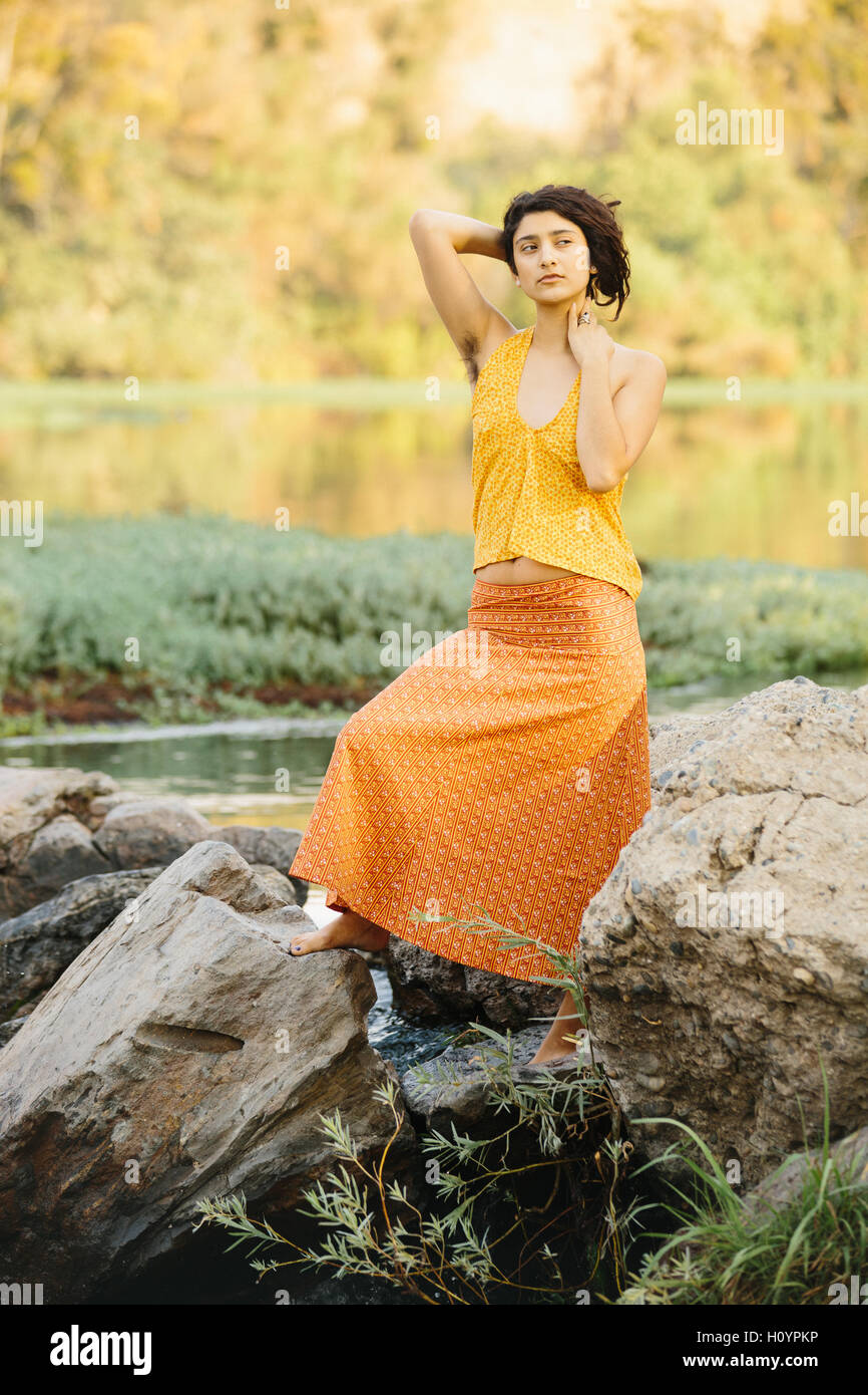 A beautiful young hippie girl with natural hair on a river beach wearing  handmade hipster fashion skirt Stock Photo - Alamy