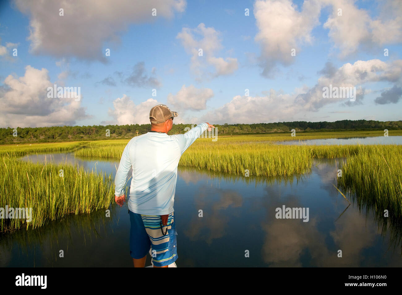 An inshore charter guide searches flats on Florida's pristine Intercoastal waterway for signs of redfish on flood tide. Stock Photo