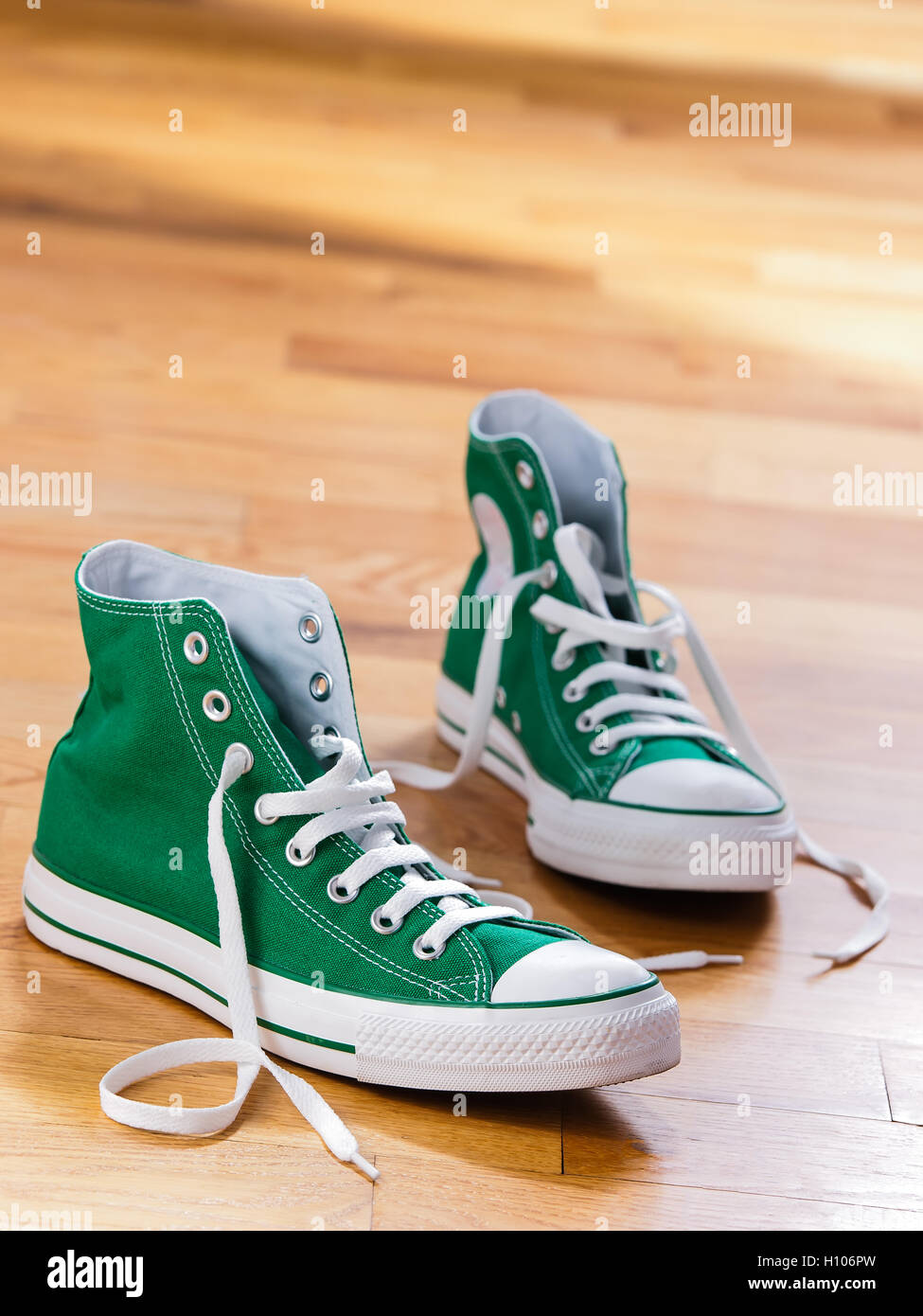 Retro green sneakers left on wooden floor Stock Photo - Alamy
