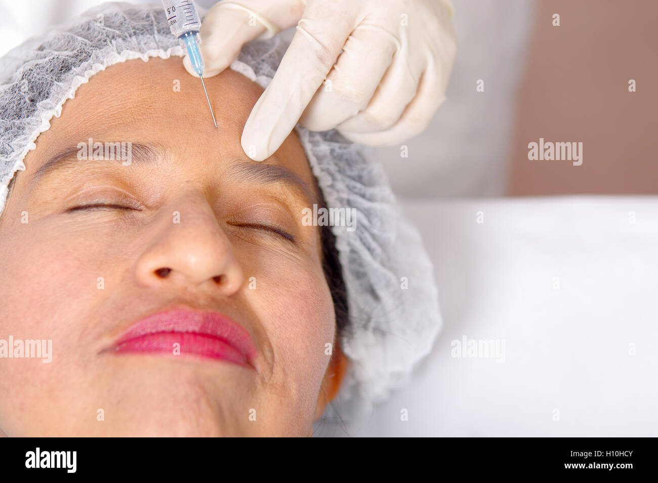 Closeup womans face receiving botox injections with syringe, cosmetic