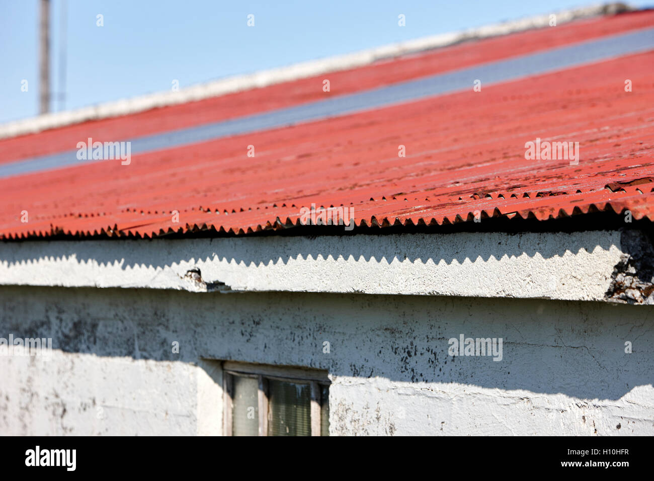 red painted corrugated metal roof on a farm outbuilding in Iceland Stock Photo