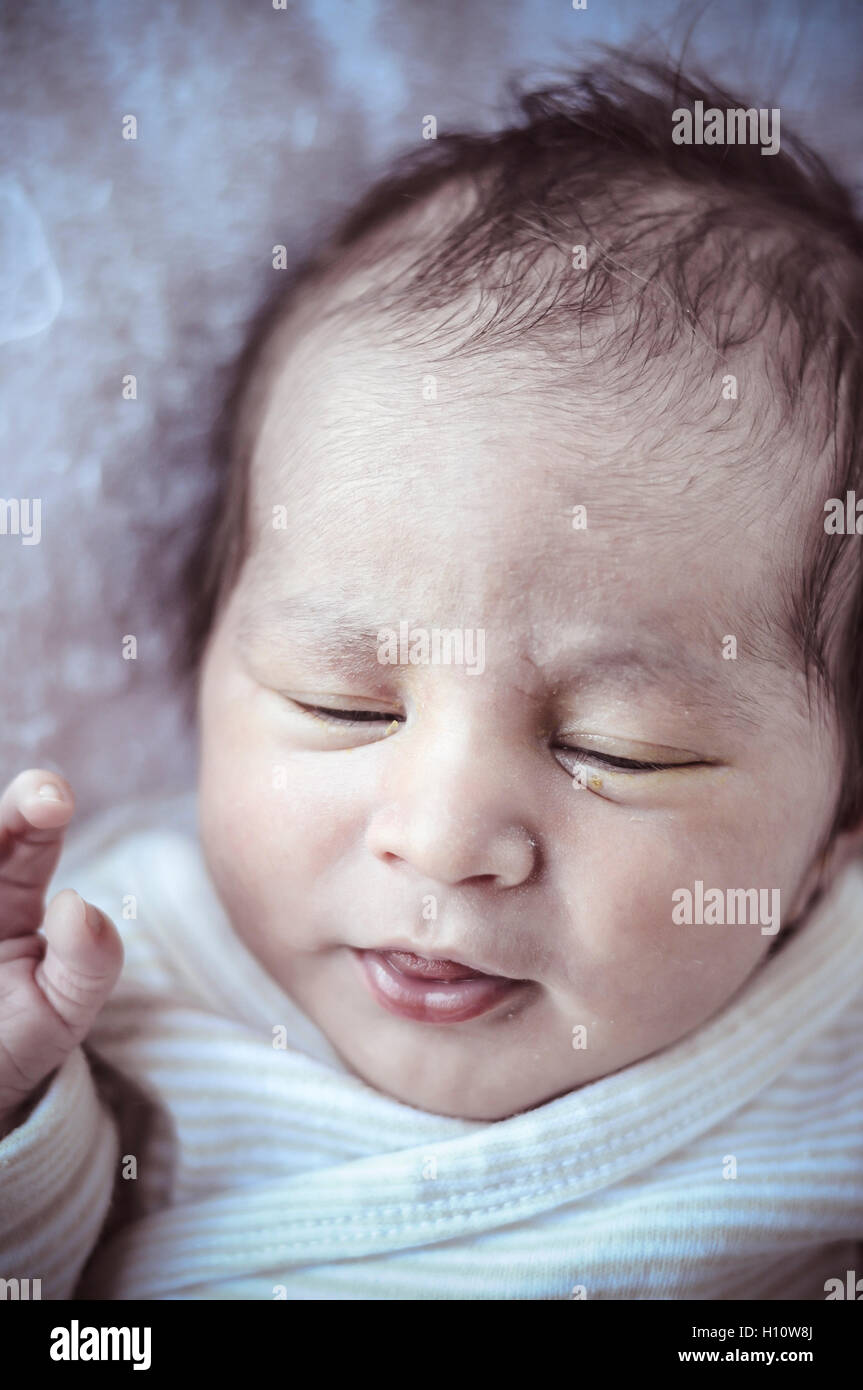 new born baby curled up sleeping on a blanket, multiple expressi Stock