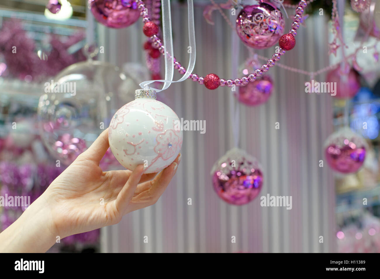 Woman holding white Christmas bauble at store Stock Photo Alamy