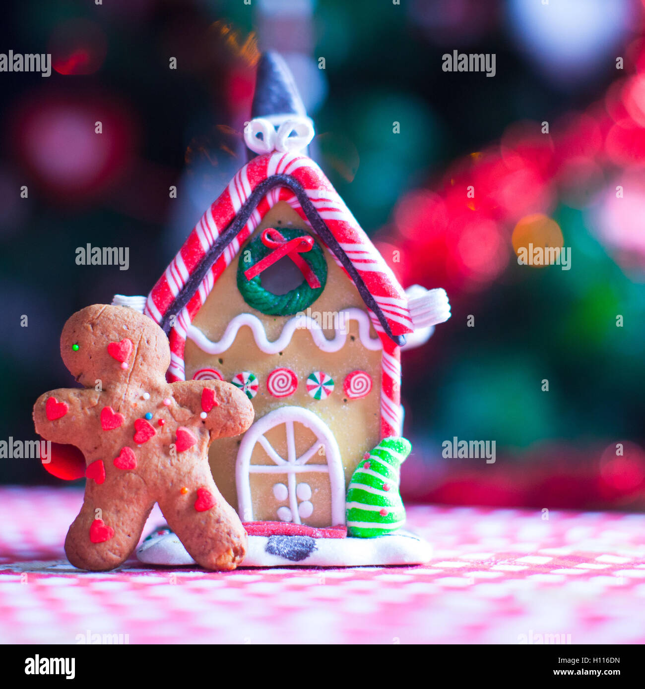 Cute gingerbread man in front of his candy ginger house background the