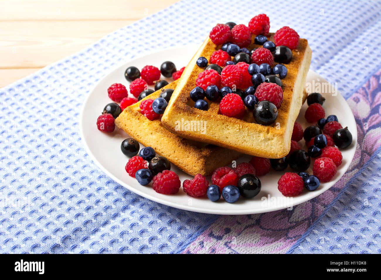 Fresh brussels waffle with blueberry, raspberry and blackcurrant. Breakfast soft waffles with fresh berries Stock Photo
