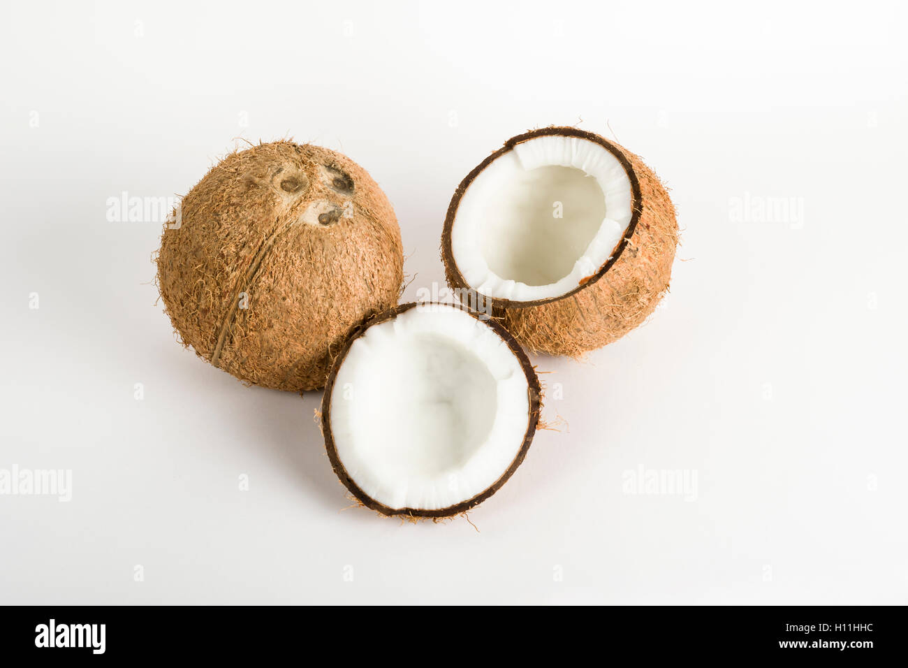Whole Coconut and cracked sections with kernel on a white background Stock Photo Alamy