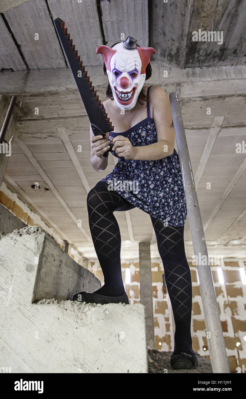 Crazy clown with saw, murderer and halloween Stock Photo