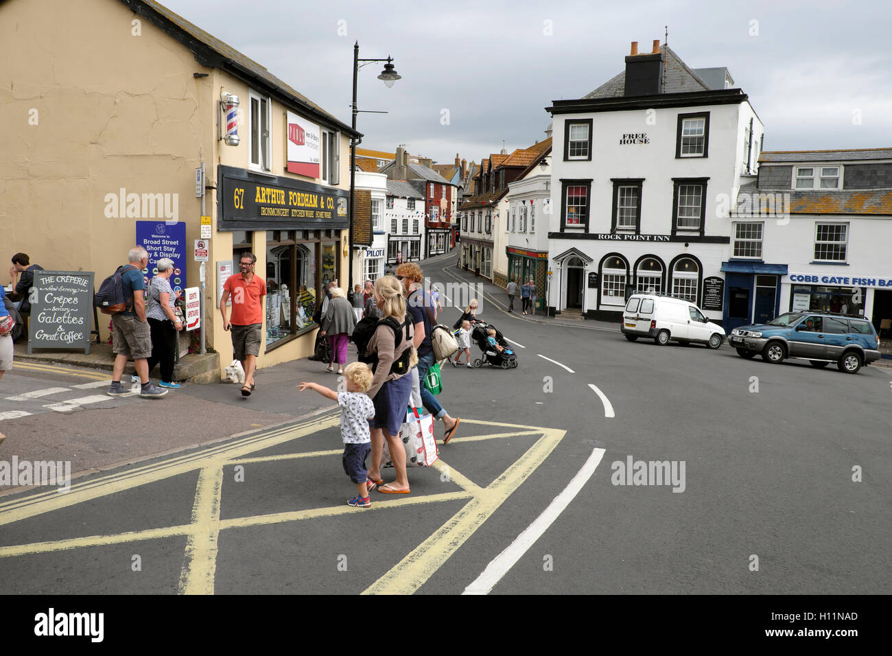 People crossing the street from the Square at Lyme Regis, Dorset, England UK    KATHY DEWITT Stock Photo