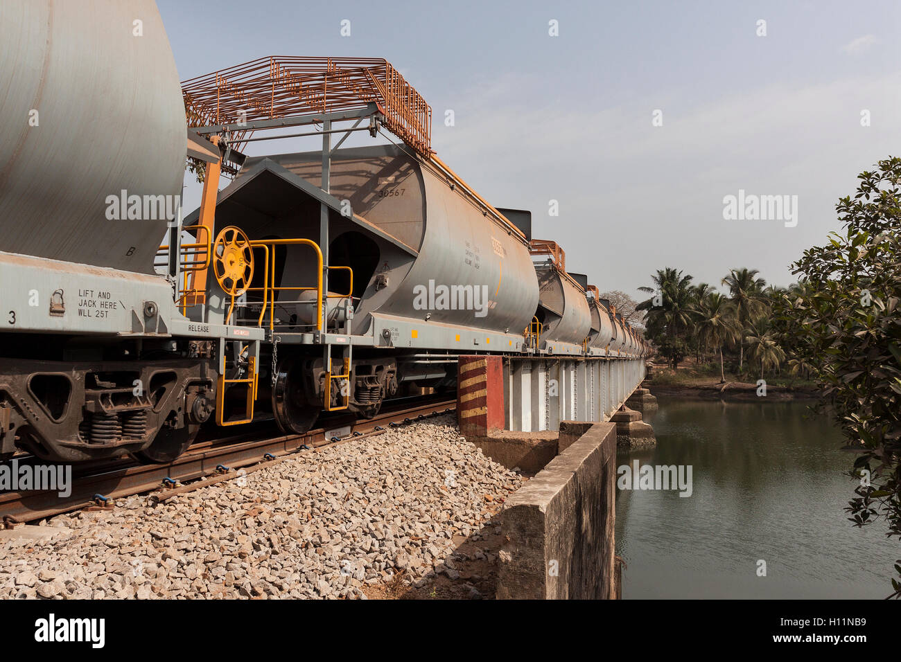 Port operations for managing and transporting iron ore. New wagons near port area with iron ore before loading onto ships for overseas markets. Stock Photo