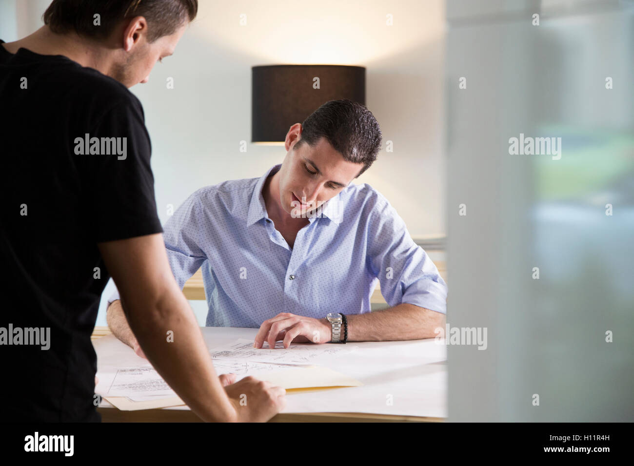 Two male office workers sharing ideas in a modern office Stock Photo