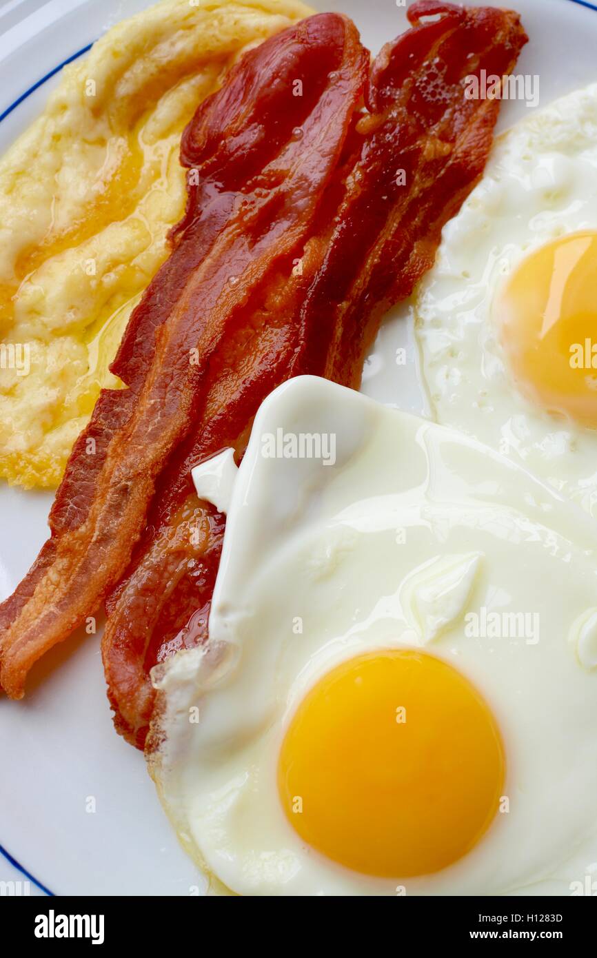 Breakfast with streaky bacon, fried eggs and grilled cheese Stock Photo