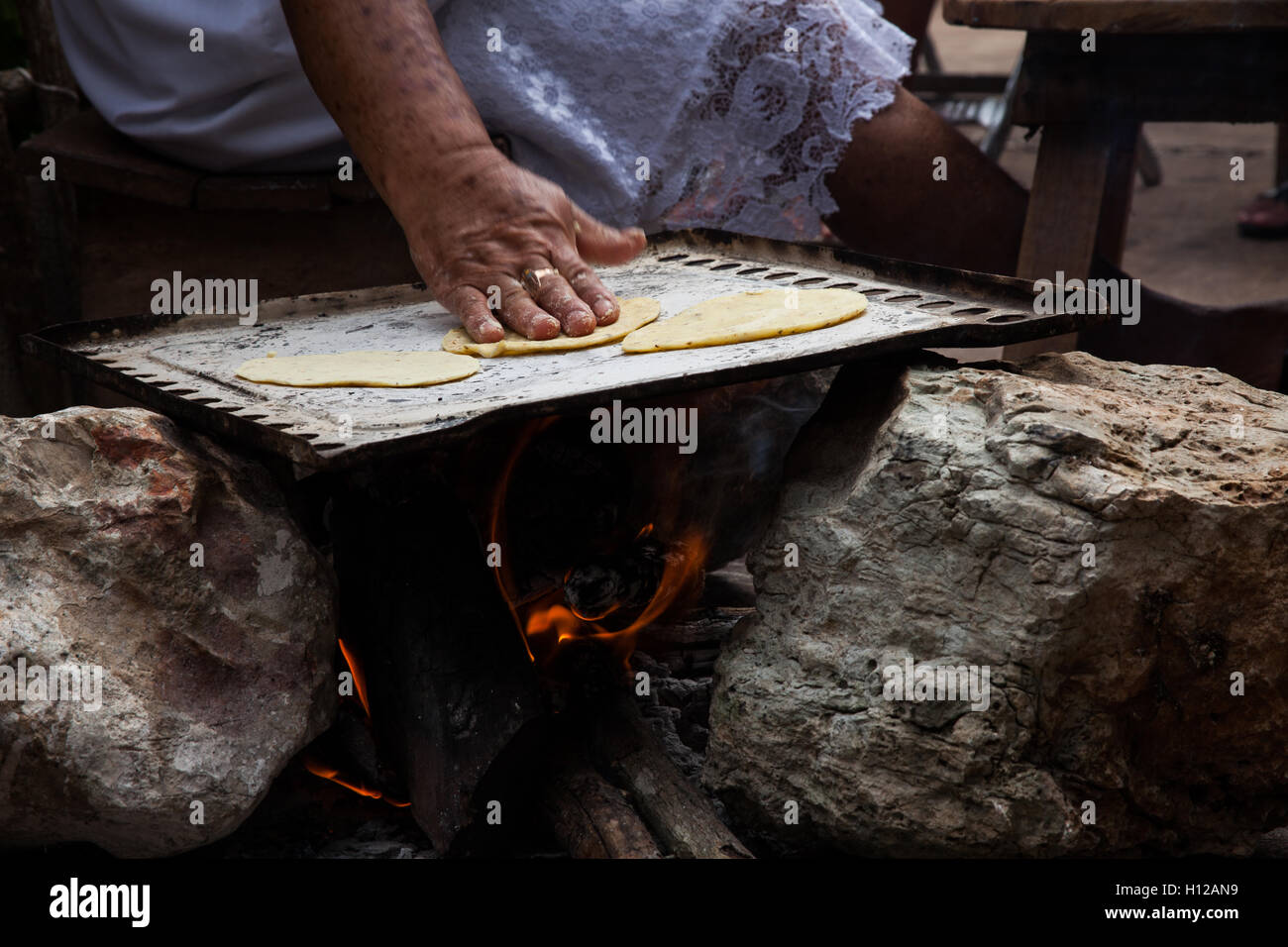 https://c8.alamy.com/comp/H12AN9/a-senior-woman-making-tortillas-in-a-metal-hotplate-called-comal-being-H12AN9.jpg