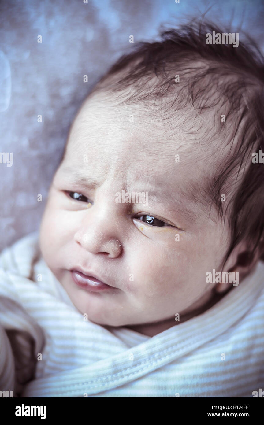 new born baby curled up sleeping on a blanket, multiple expressi Stock