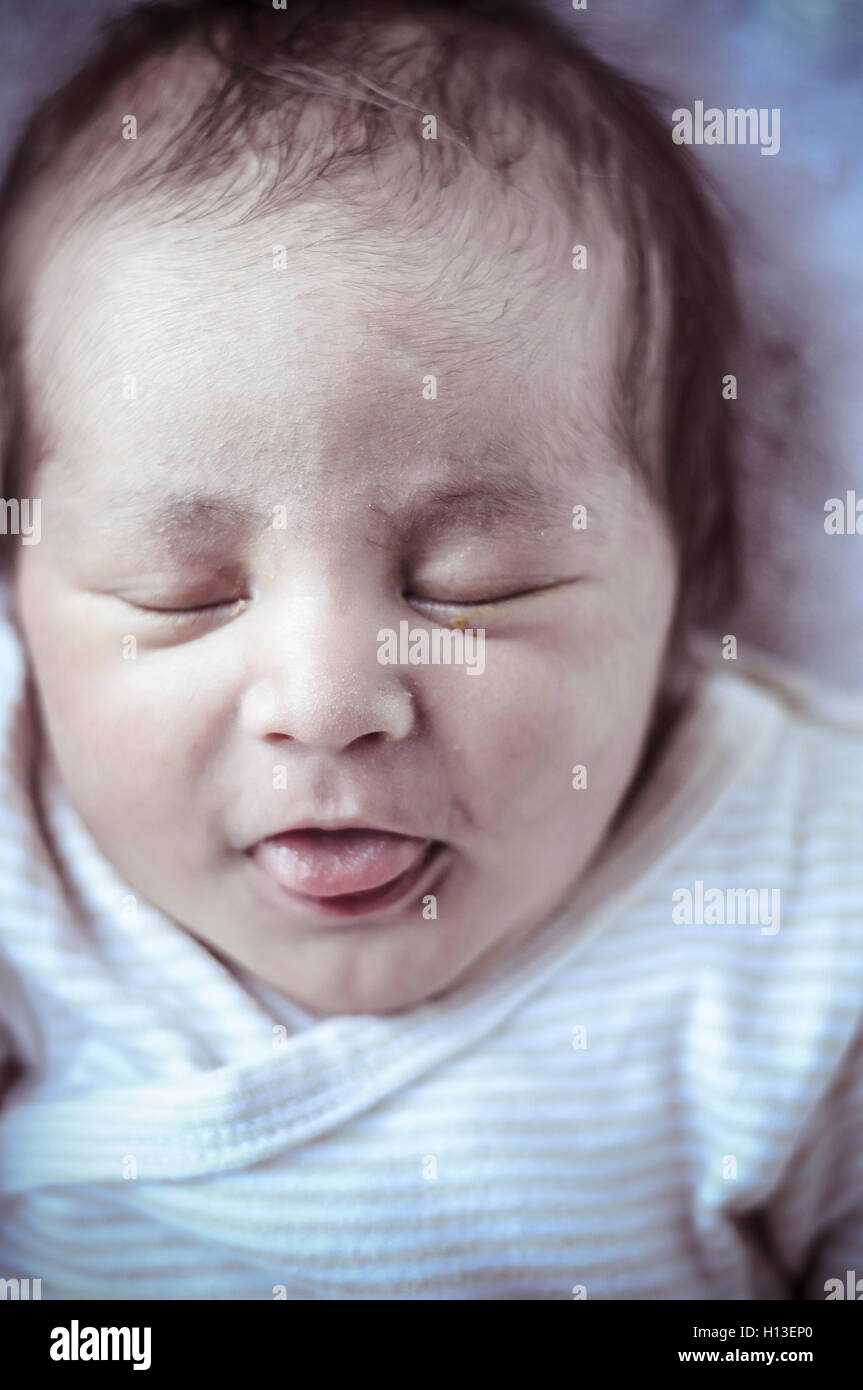 Adorable,new born baby curled up sleeping on a blanket, multiple Stock