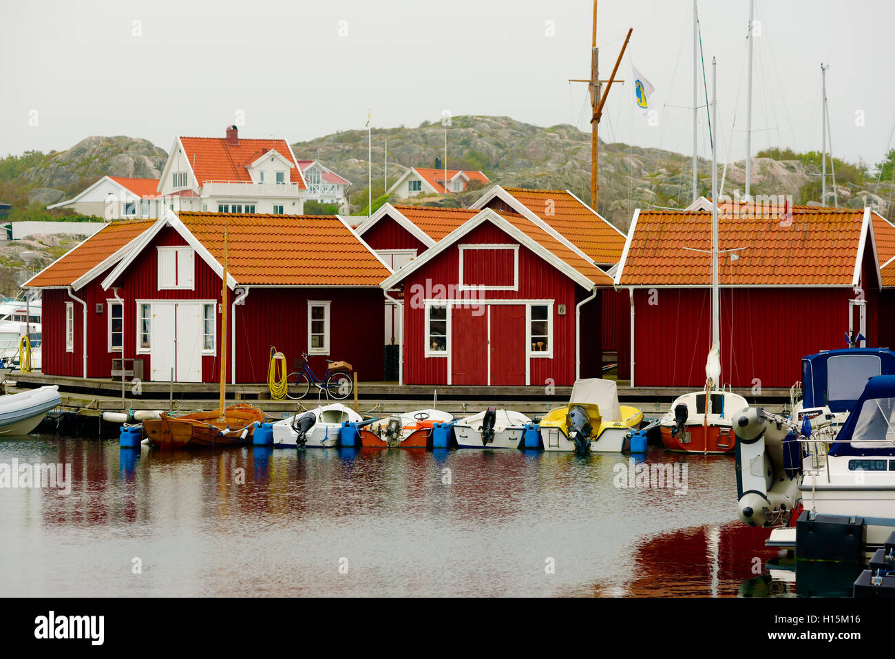 Skarhamn, Sweden - September 9, 2016: Environmental documentary of red wooden cabins in the town marina one misty morning in fal Stock Photo