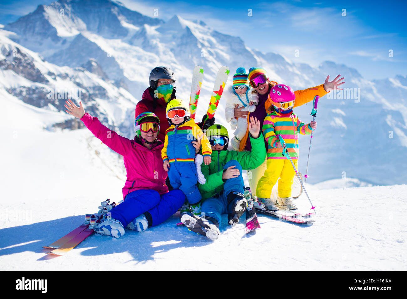 Family ski vacation. Group of skiers in Swiss Alps mountains. Adults and young children, teenager and baby skiing in winter. Stock Photo