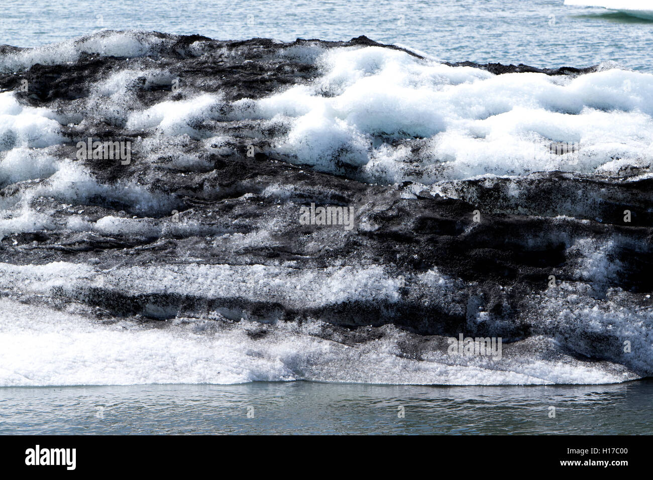 cross section of glacial ice with ash in iceberg Jokulsarlon glacial lagoon Iceland Stock Photo