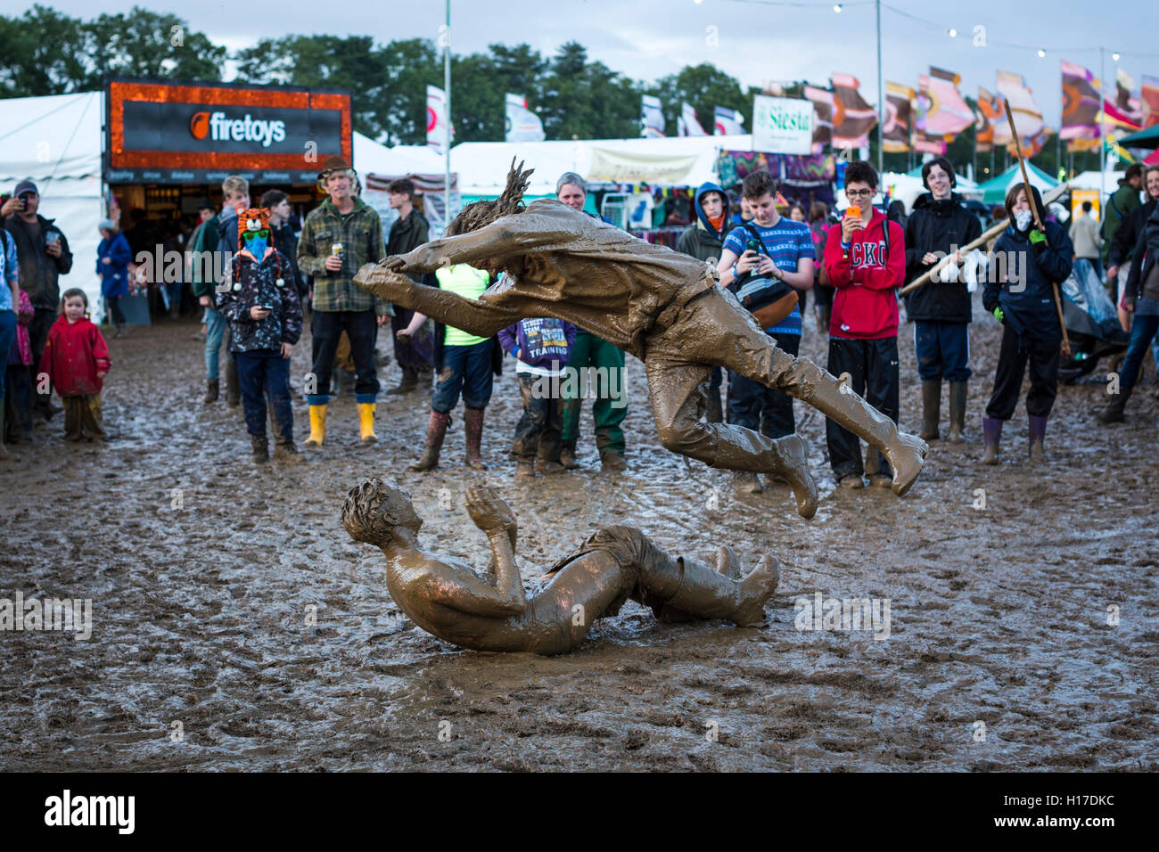 Friends mud wrestling at the 2015 Womad festival, Malmesbury, UK. Stock Photo