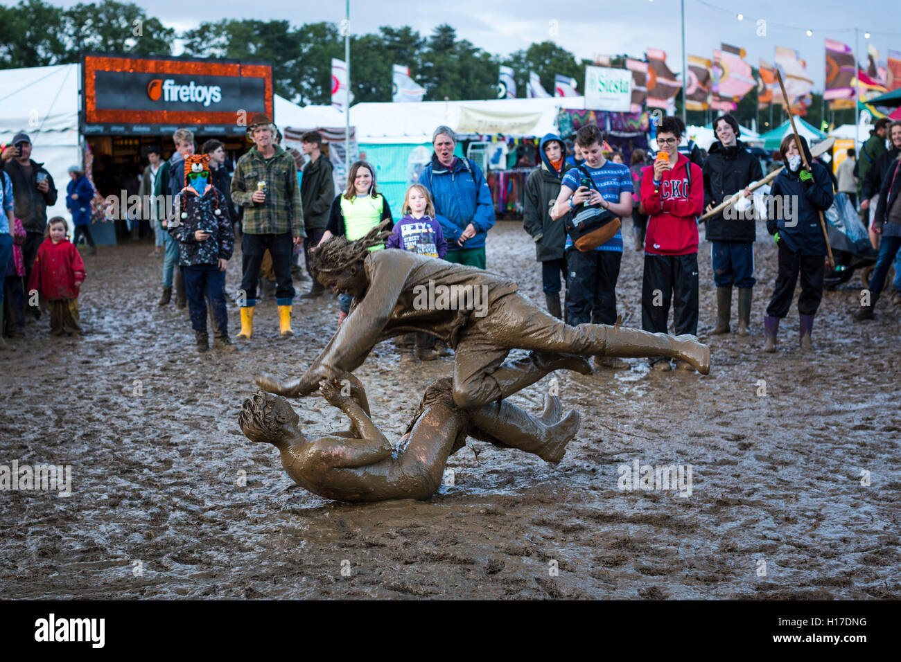 Friends mud wrestling at the 2015 Womad festival, Malmesbury, UK. Stock Photo