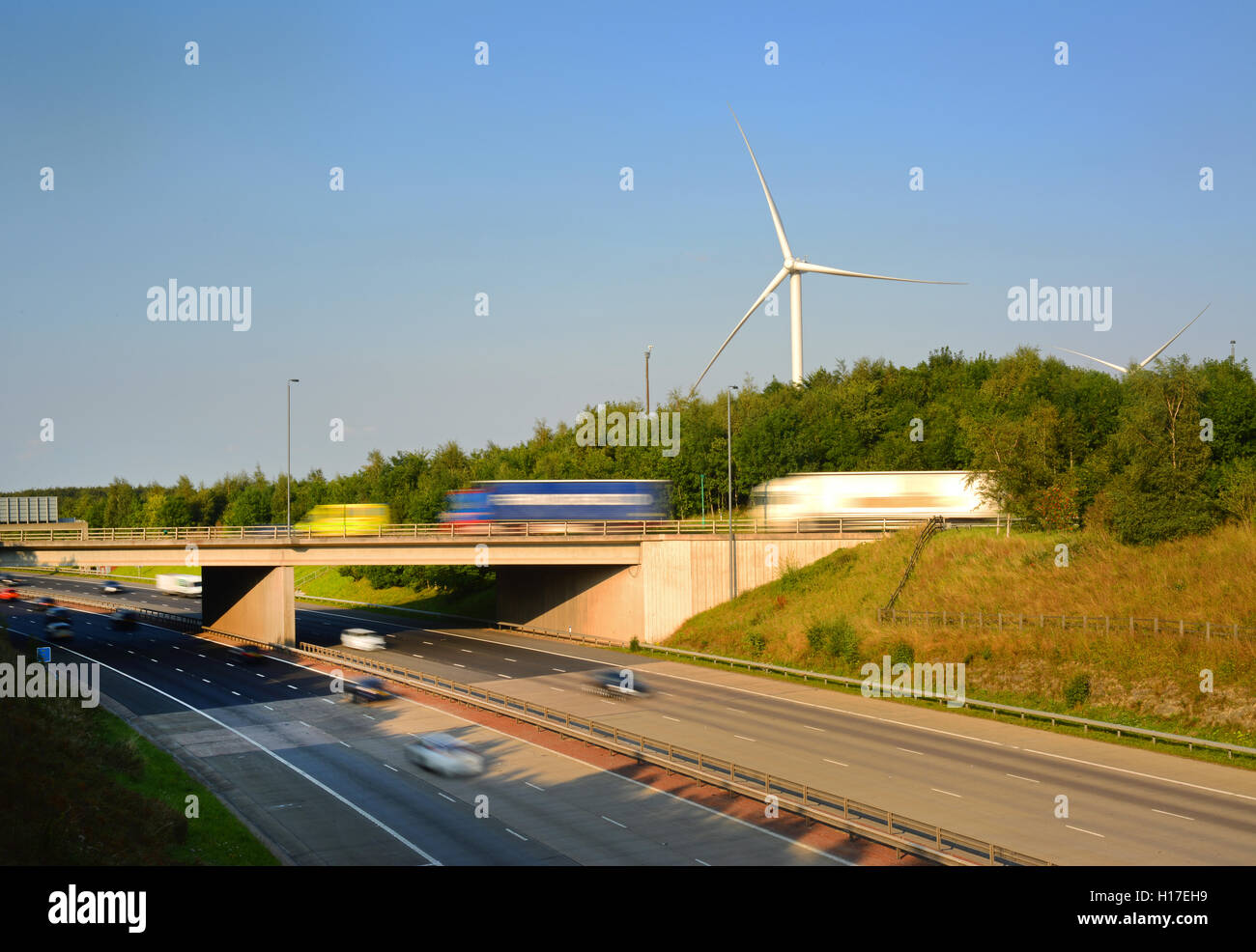 traffic passing electricity generating windmills by A1/M motorway leeds united kingdom Stock Photo