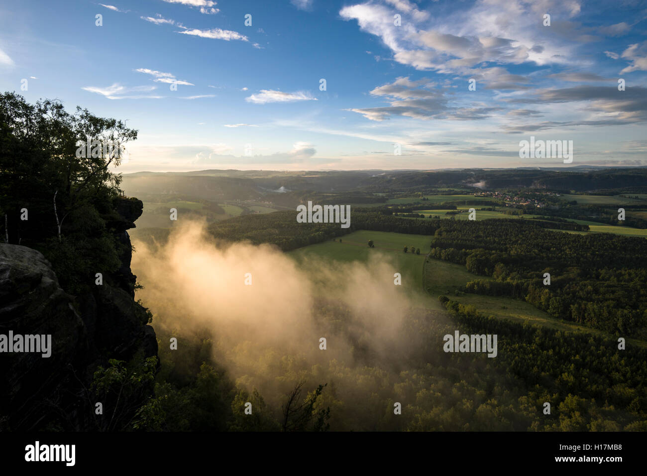 Fog is arising over the hills of Elbsandsteingebirge, seen from Lilienstein in the last light of the day, Königstein, Saxony Stock Photo