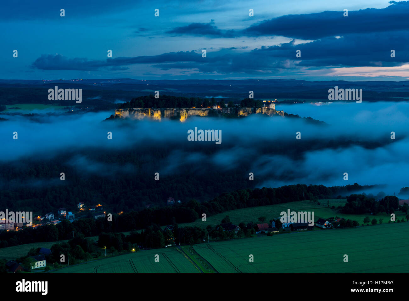 The illuminated fortress Festung Königstein, surrounded by clouds, seen from Lilienstein at night, Königstein, Saxony, Germany Stock Photo