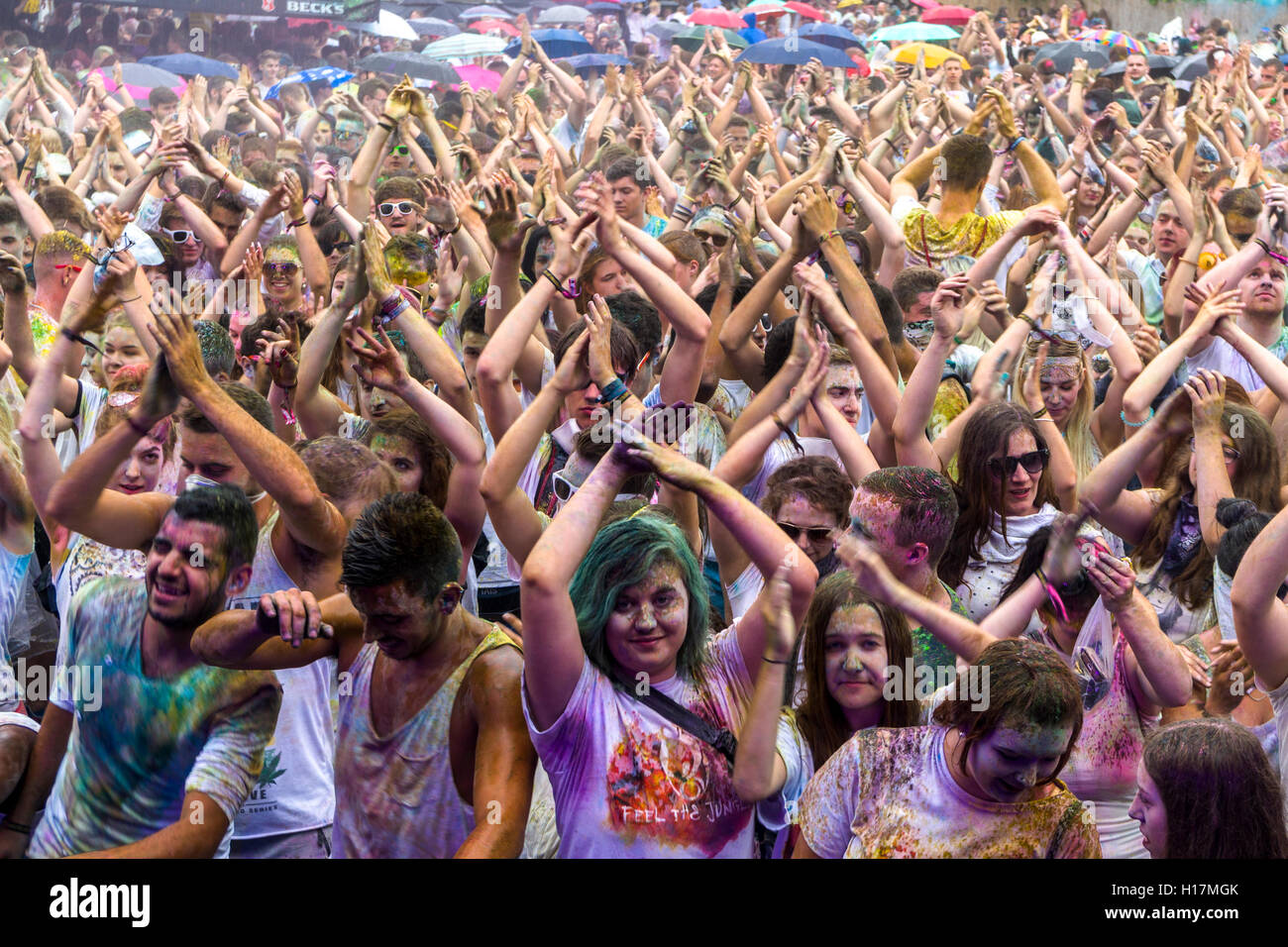 Thousands of young women and man are raising their arms at the colorful Holi festival, Dresden, Saxony, Germany Stock Photo