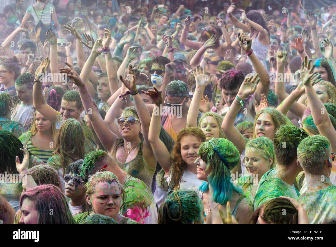 Thousands of young women and man are raising their arms at the colorful Holi festival, Dresden, Saxony, Germany Stock Photo