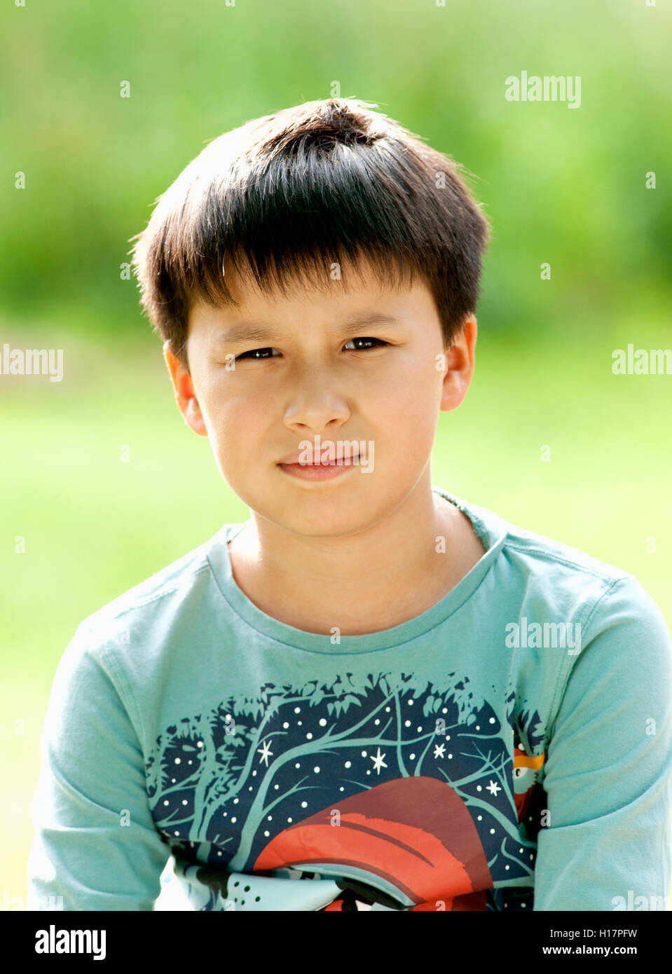 Portrait of a Boy with Dark Hair Outdoors Stock Photo