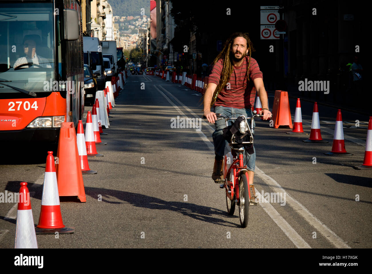 A man  rides his bicycle by Via Laietana street in Barcelona downtown. Stock Photo