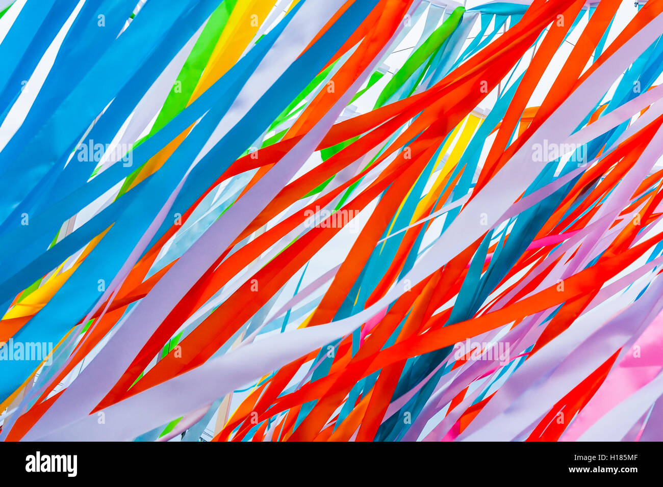 Colorful fabric ribbons wave in the wind. Play of red, blue, pink and other colors. Abstract pattern or texture Stock Photo