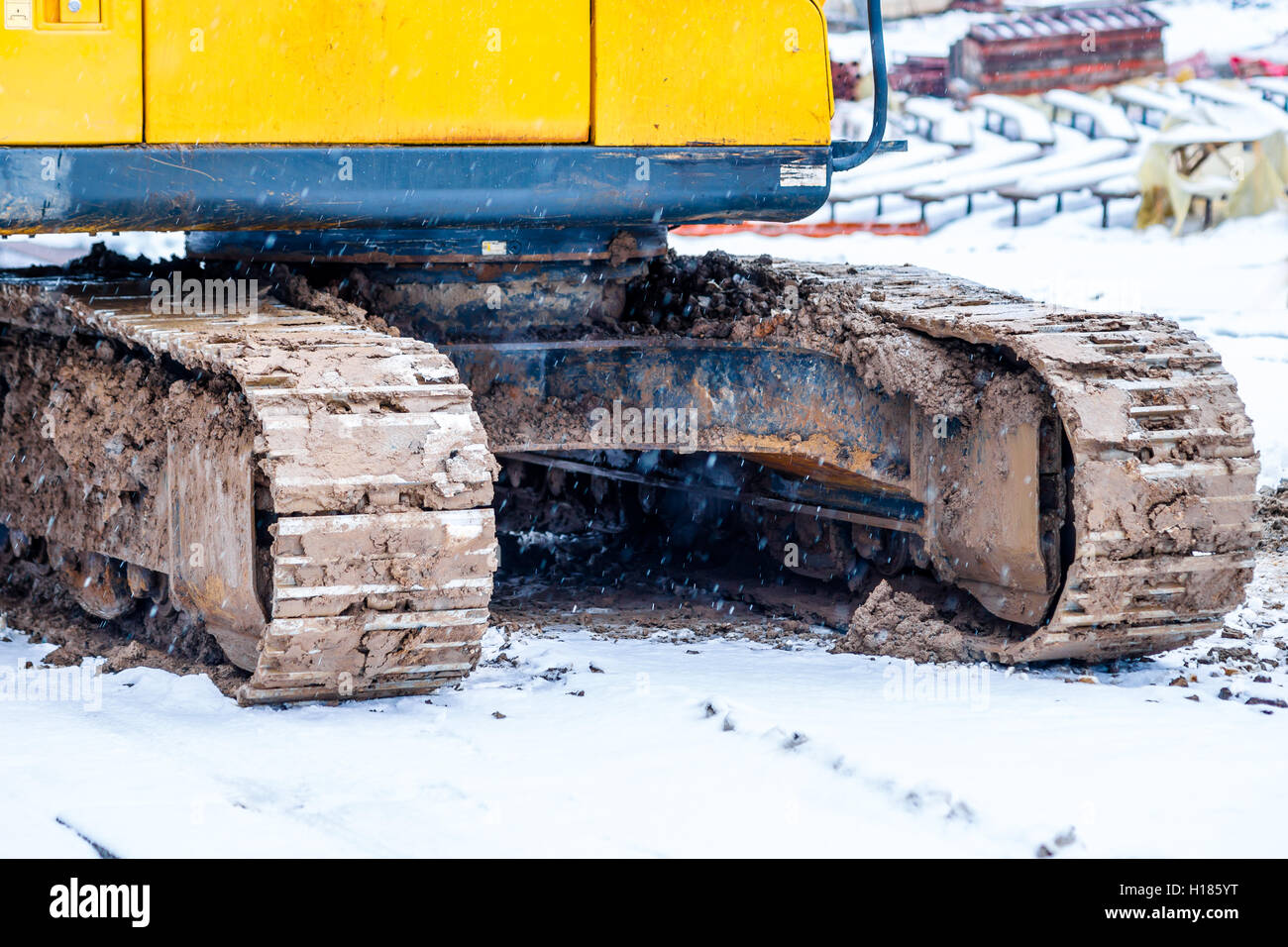 Dirty tracks of a caterpillar chovel which stands on a construction site. Winter season, snow and snowfall Stock Photo