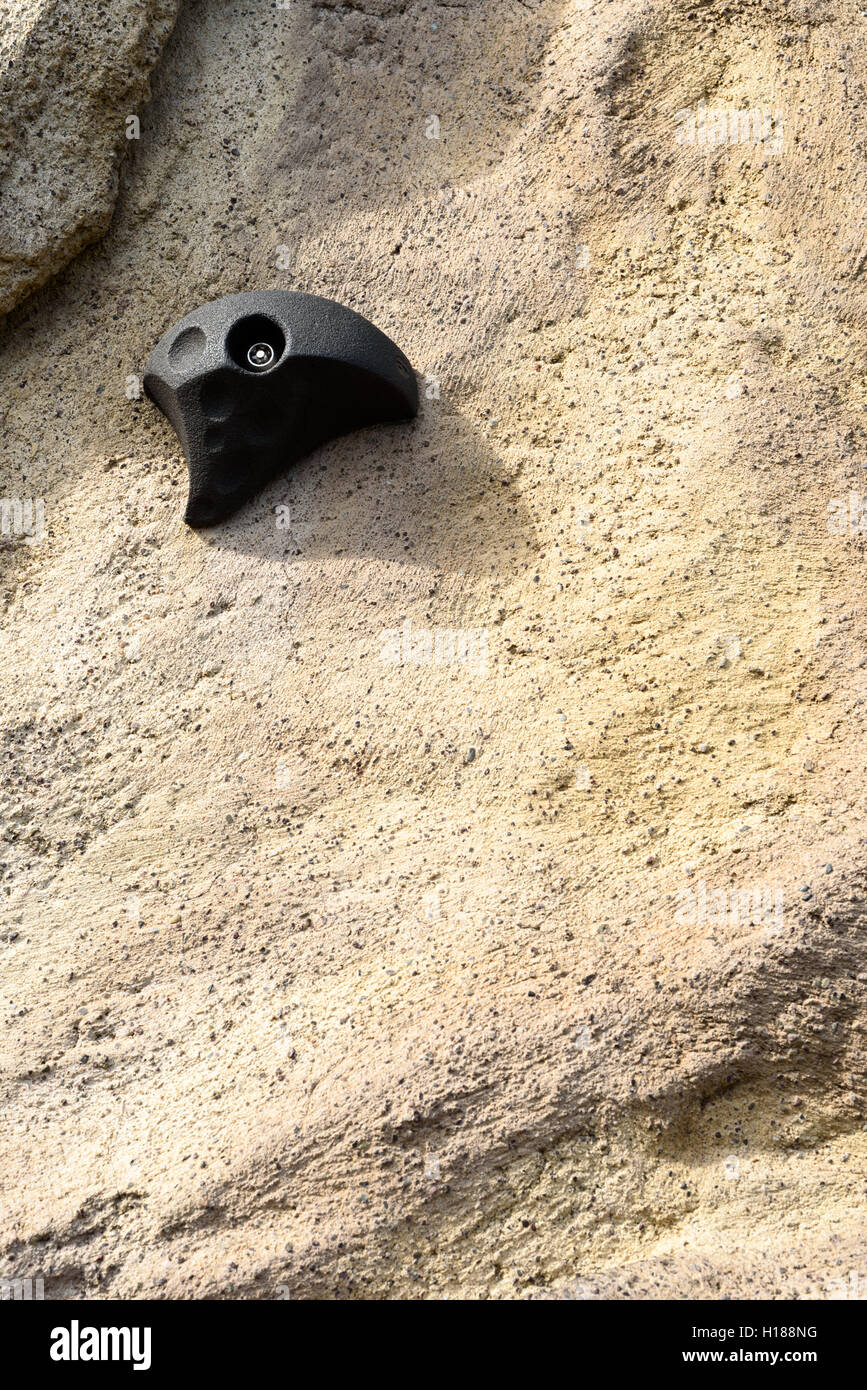 Single rock climbing grip on a stone background. copy space area for adventure sports and active lifestyle text designs. Stock Photo