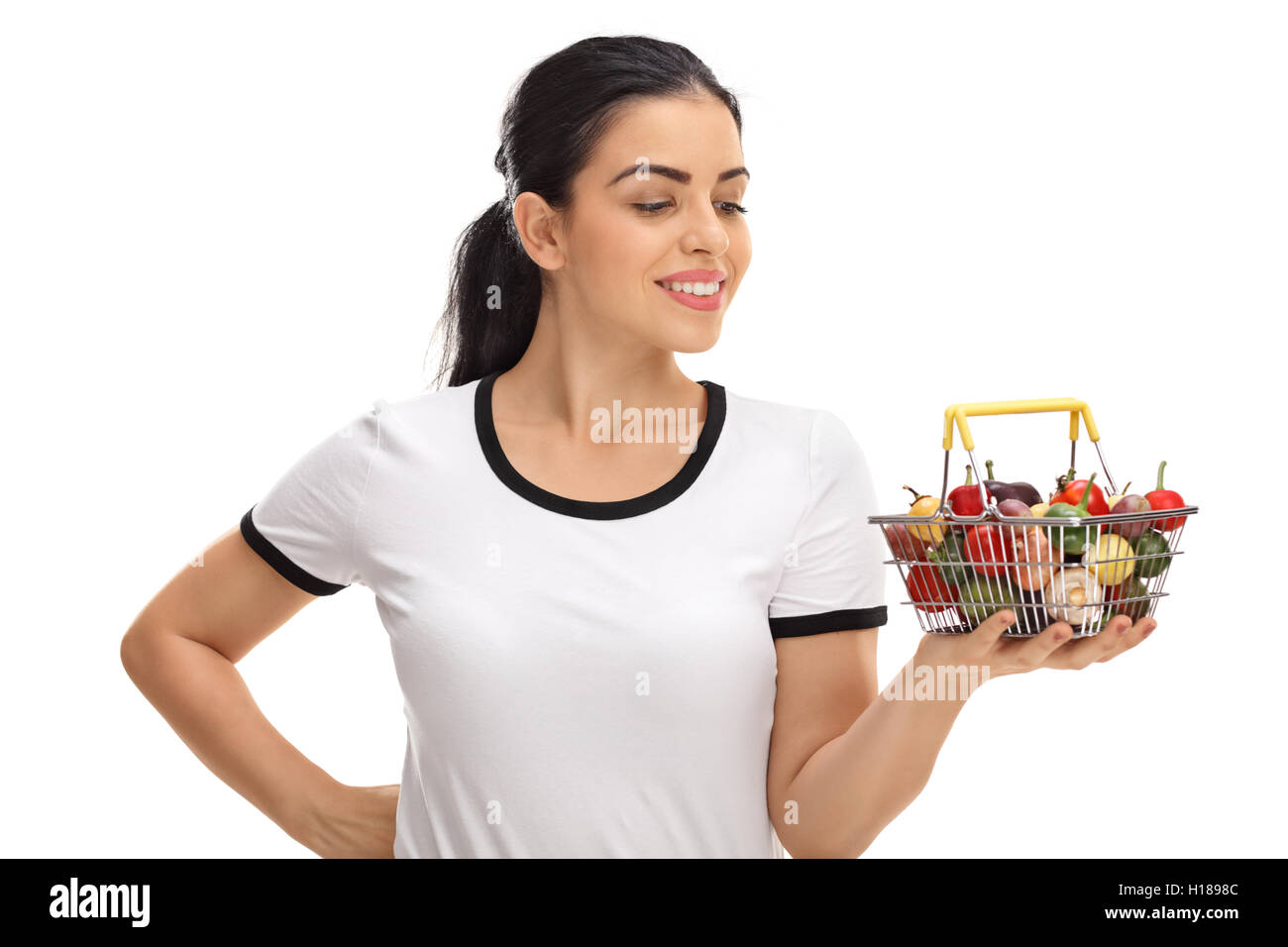 Young woman looking at a small shopping basket full of fruits and ...
