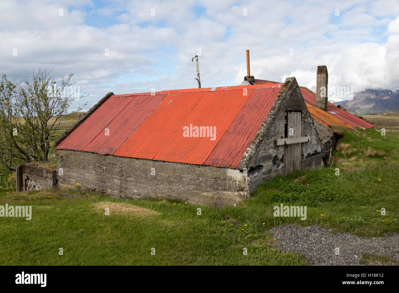 partially buried red tin roofed farm outbuildings in southern iceland Stock Photo