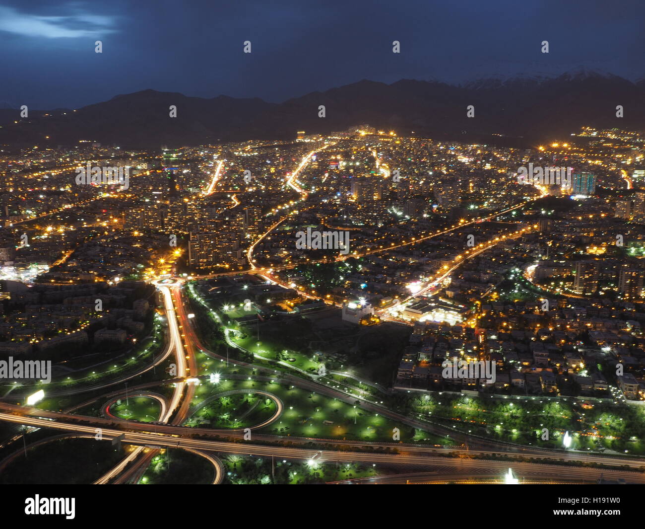 Tehran city at night with Alborz mountain range backdrop Stock Photo