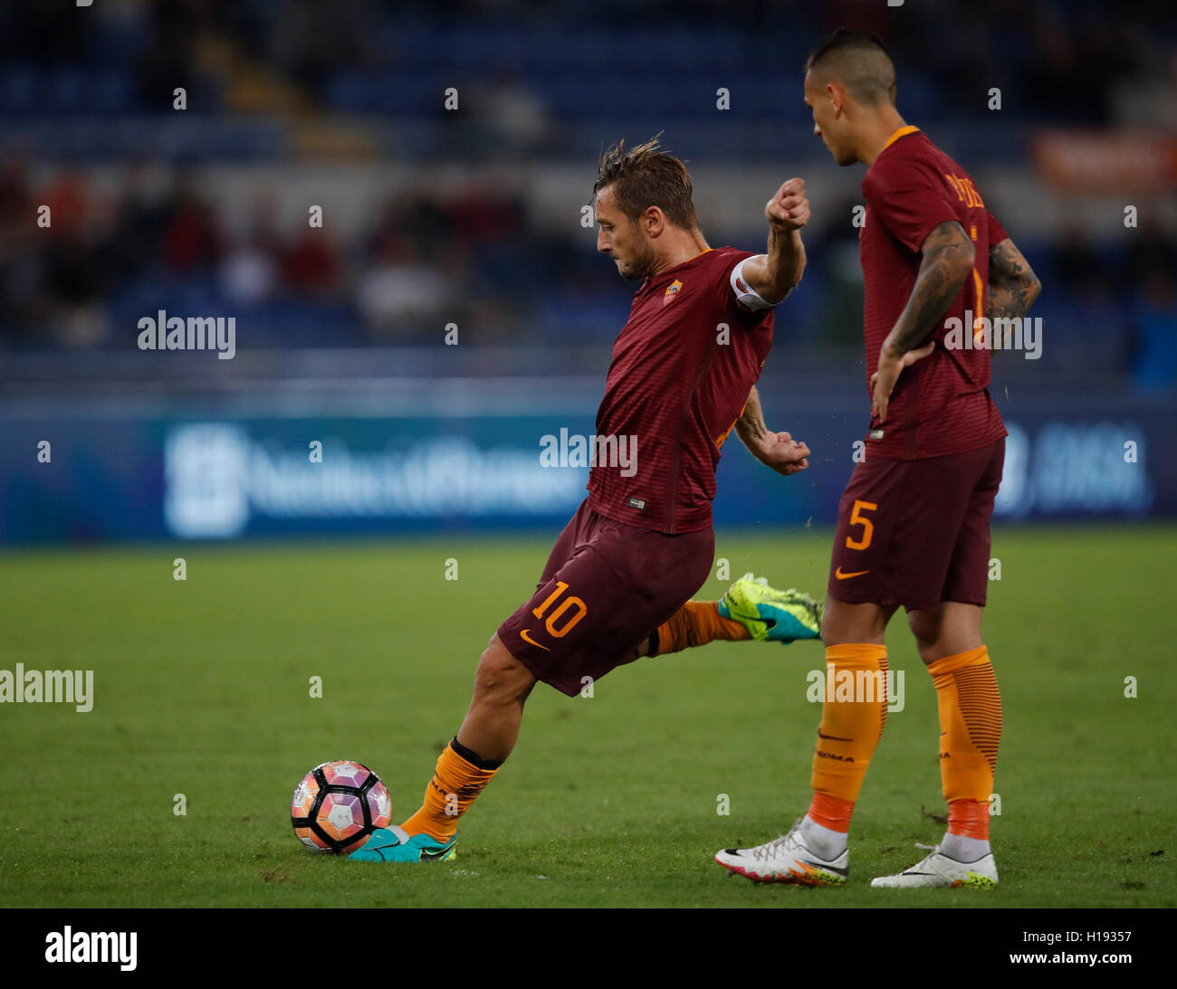Rome, Italy. 21st Sep, 2016. Roma's Francesco Totti, left, flanked by  teammate Leandro Paredes, kicks the ball during the Serie A soccer match  between Roma and Crotone at the Olympic stadium. Roma