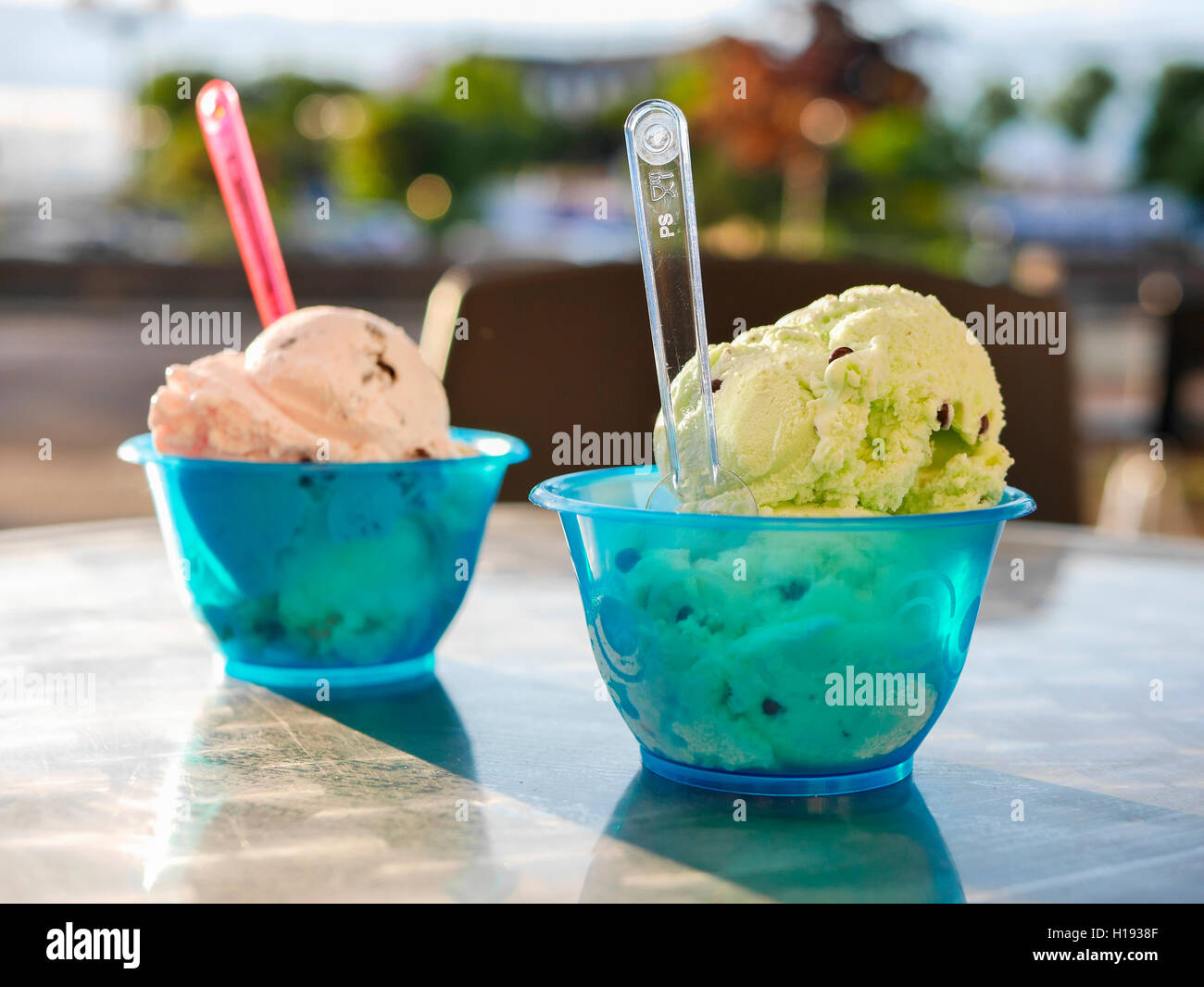 Two small tubs of ice cream sitting on an outside table Stock Photo