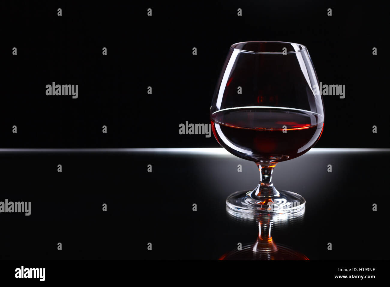 Snifter with brandy on a reflective background Stock Photo Alamy