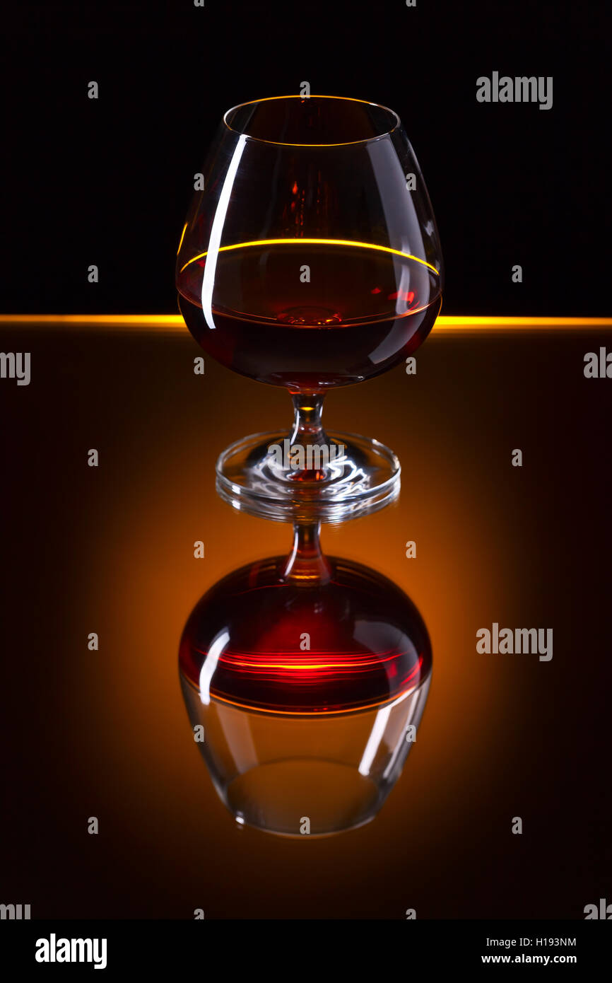 Snifter with brandy on a reflective background Stock Photo Alamy