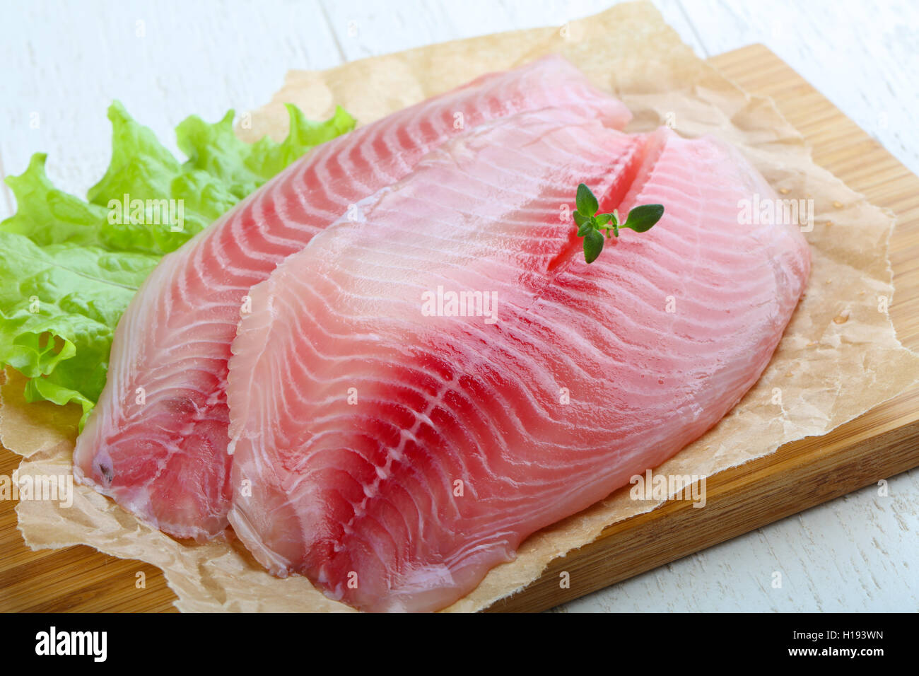 Raw tilapia fish fillet with thyme ready for cooking Stock Photo Alamy