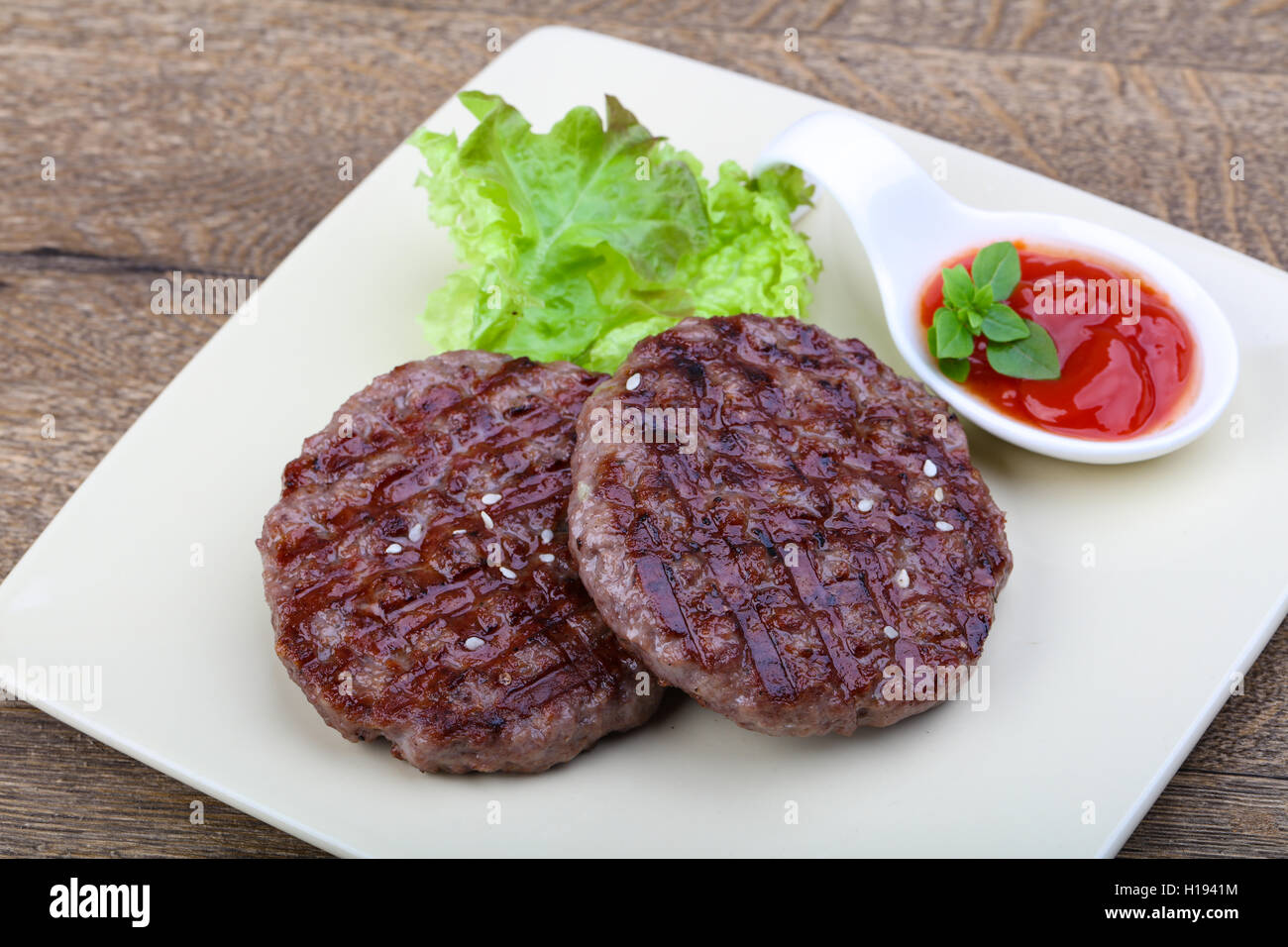 Grilled burger cutlet with onion and salad leaves Stock Photo Alamy