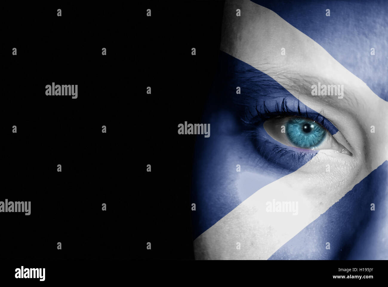 A young female with the flag of Scotland painted on her face on her way to a sporting event to show her support. Stock Photo