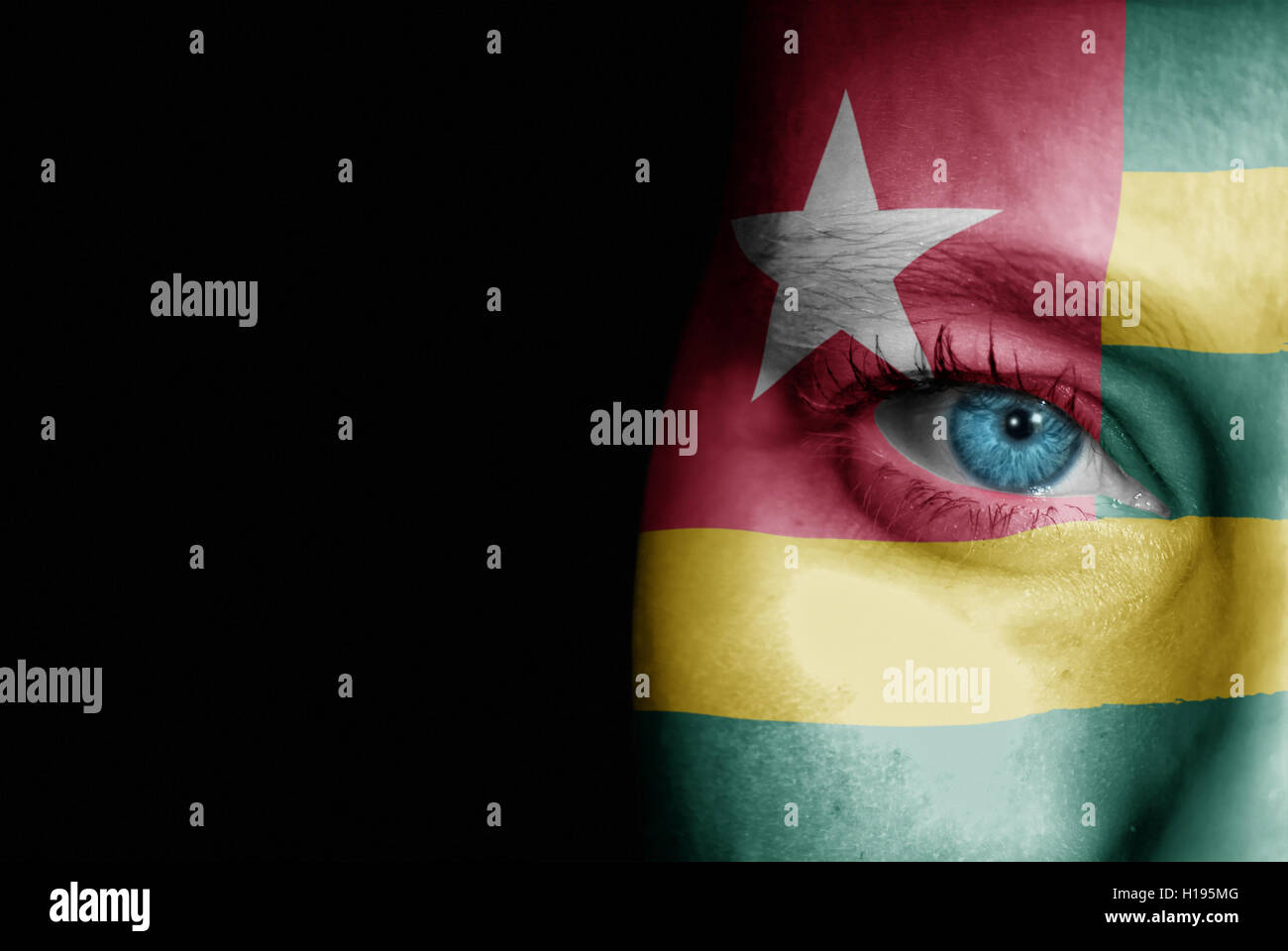 A young female with the flag of Togo painted on her face on her way to a sporting event to show her support. Stock Photo