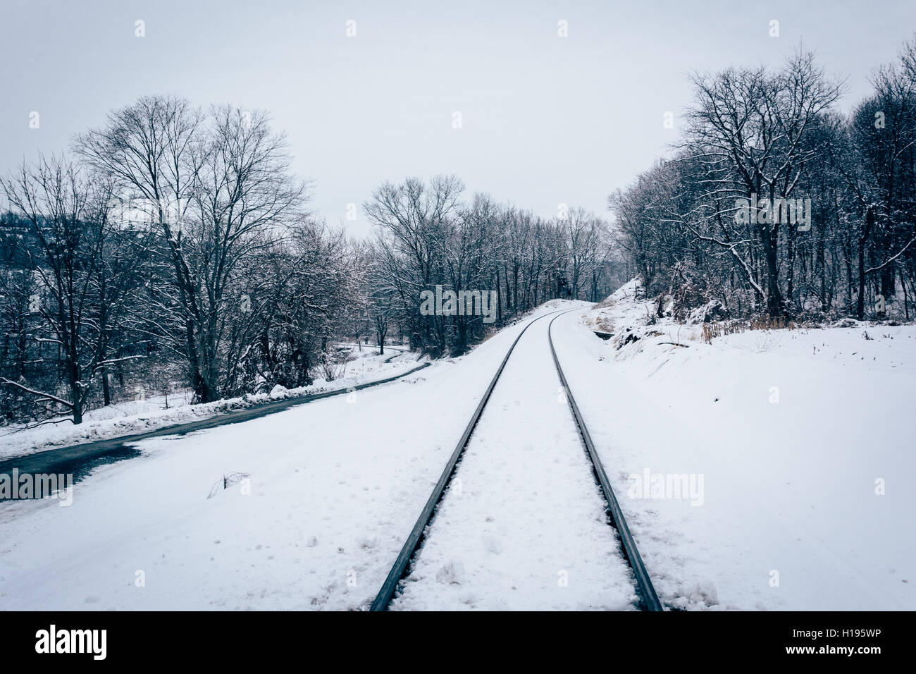 Snow covered railroad track and road in Baltimore County, Maryland. Stock Photo