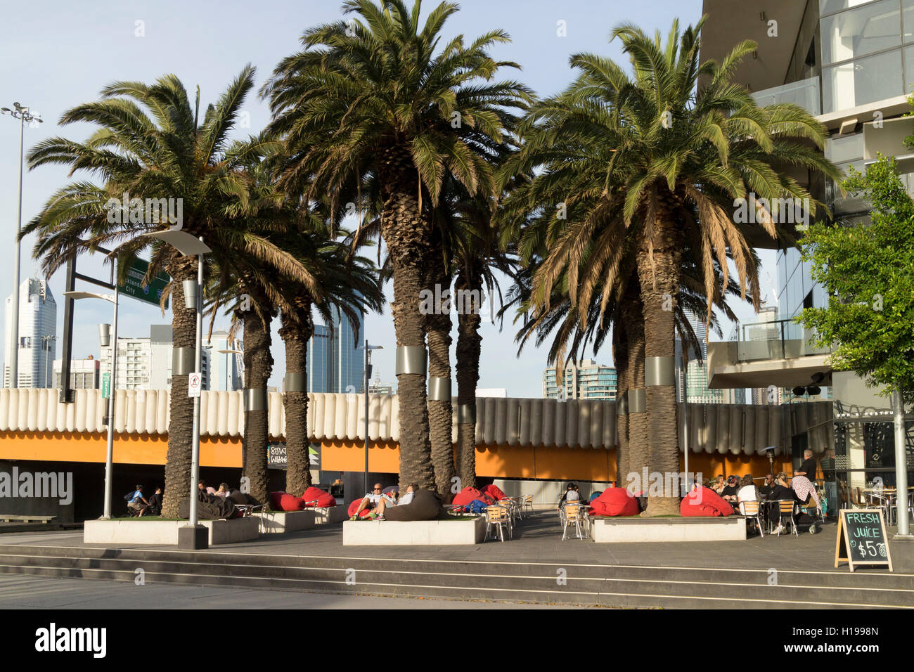 Patrons relaxing on red cushions at coffee shop in Victoria Harbour
