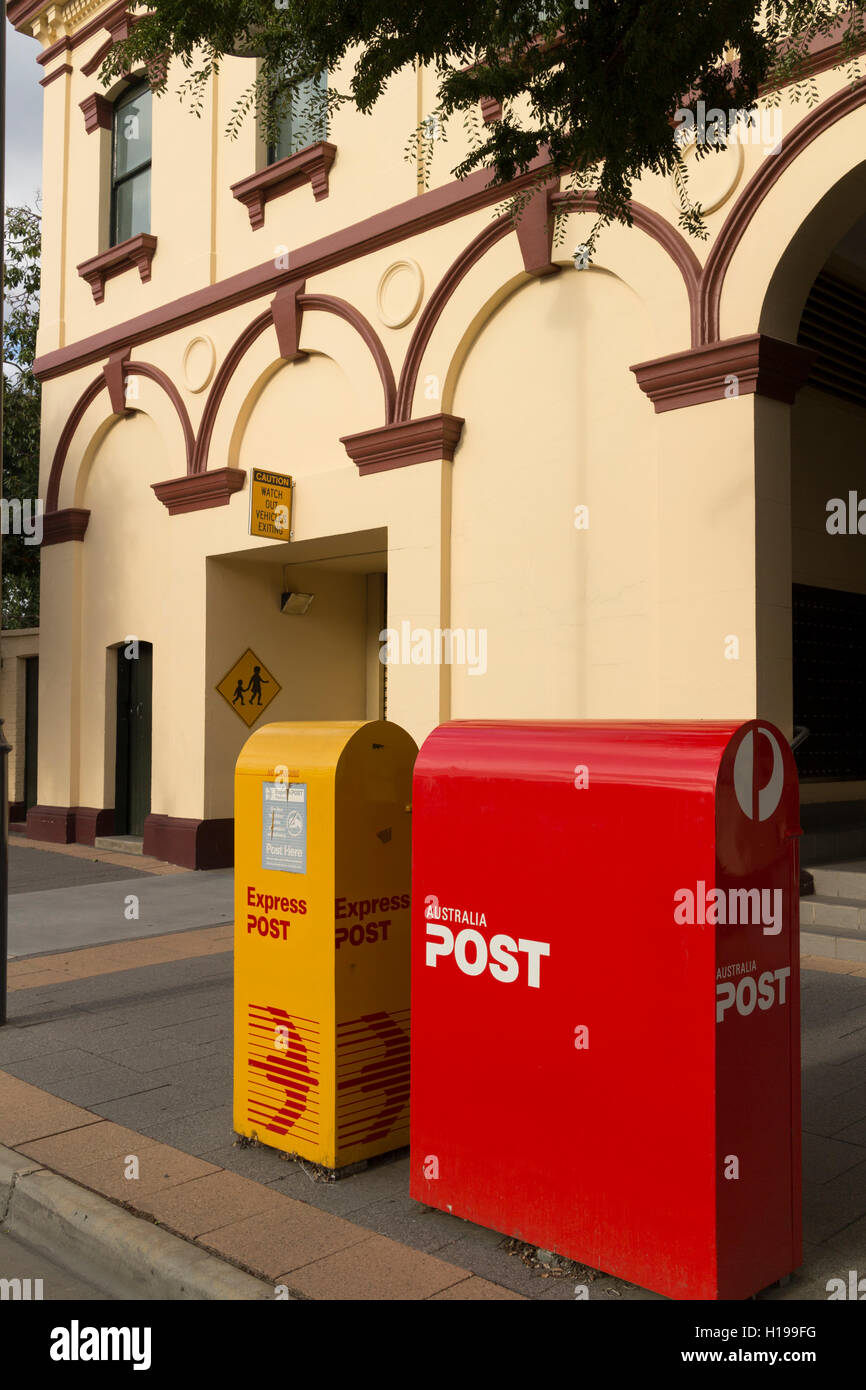 Snail mail and express post yellow and red boxes outside the  post office Albury NSW Australia Stock Photo
