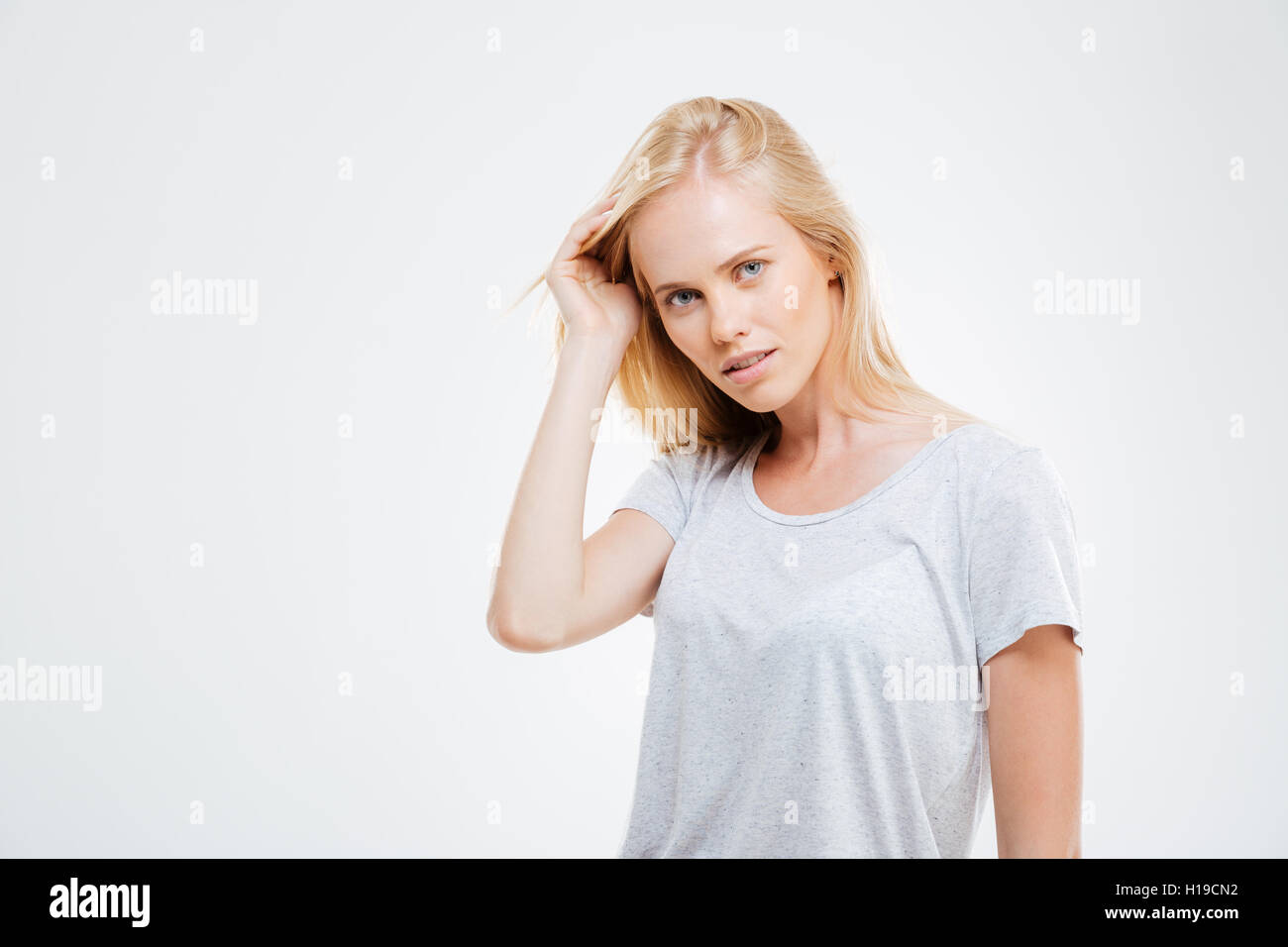 Portrait of confident beautiful young woman with blonde hair over white background Stock Photo