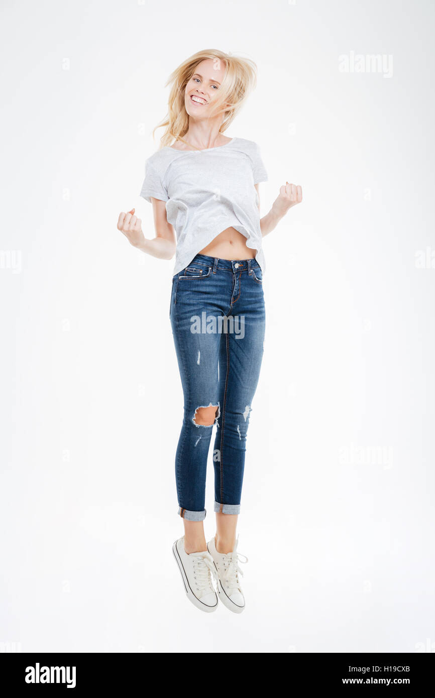 Full length portrait of a cheerful woman jumping isolated on a white ...