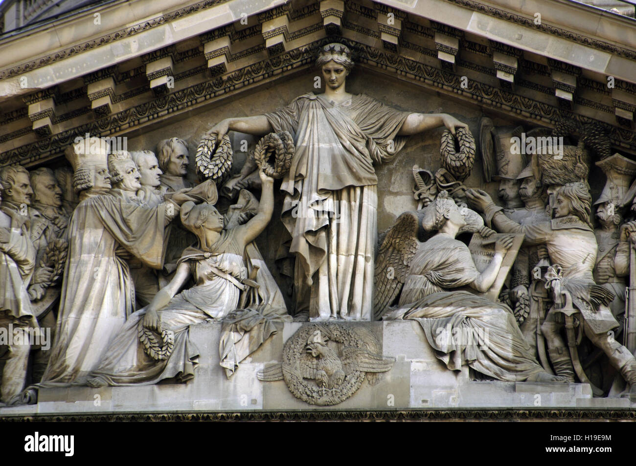 France. Paris. Pantheon's pediment. Detail. Sculpted by Pierre-Jean David d’Angers (1788-1856). In the center, the Republic handing crowns to Liberty (left) while History (right corner) writes down the names of those deemed worthy of the crowns. In the first row, the recipients are Malesherbes, Mirabeau, Monge and Fenelon. In the second row are Lazare Carnot, Berthollet and Laplace. To the right of the central group, Napoleon Bonaparte leads an army of anonymous soldiers. Stock Photo
